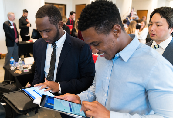 An image of students attending a career fair networking with an employer.