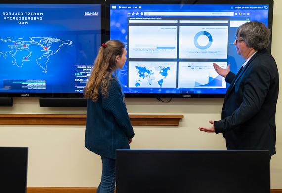 Image of cybersecurity faculty member teaching a student.